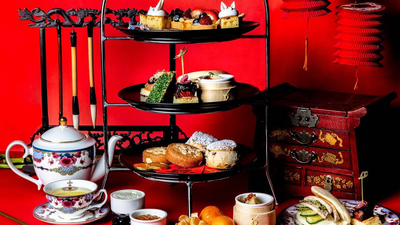 A table set with red and black dishes and tea.