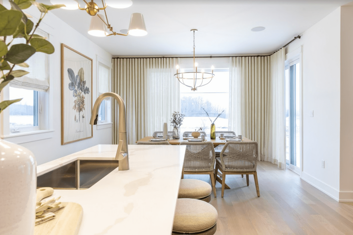 A view of a dining table from next to a kitchen island.