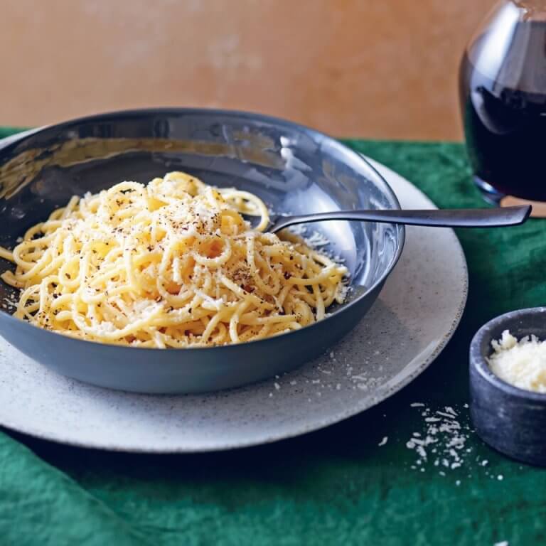 A blue dish with cacio e pepe on a plate.