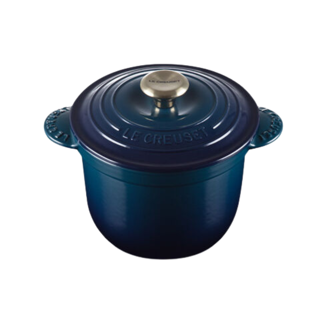 A blue Le Creuset rice pot with tab handles and a silver knob on lid.