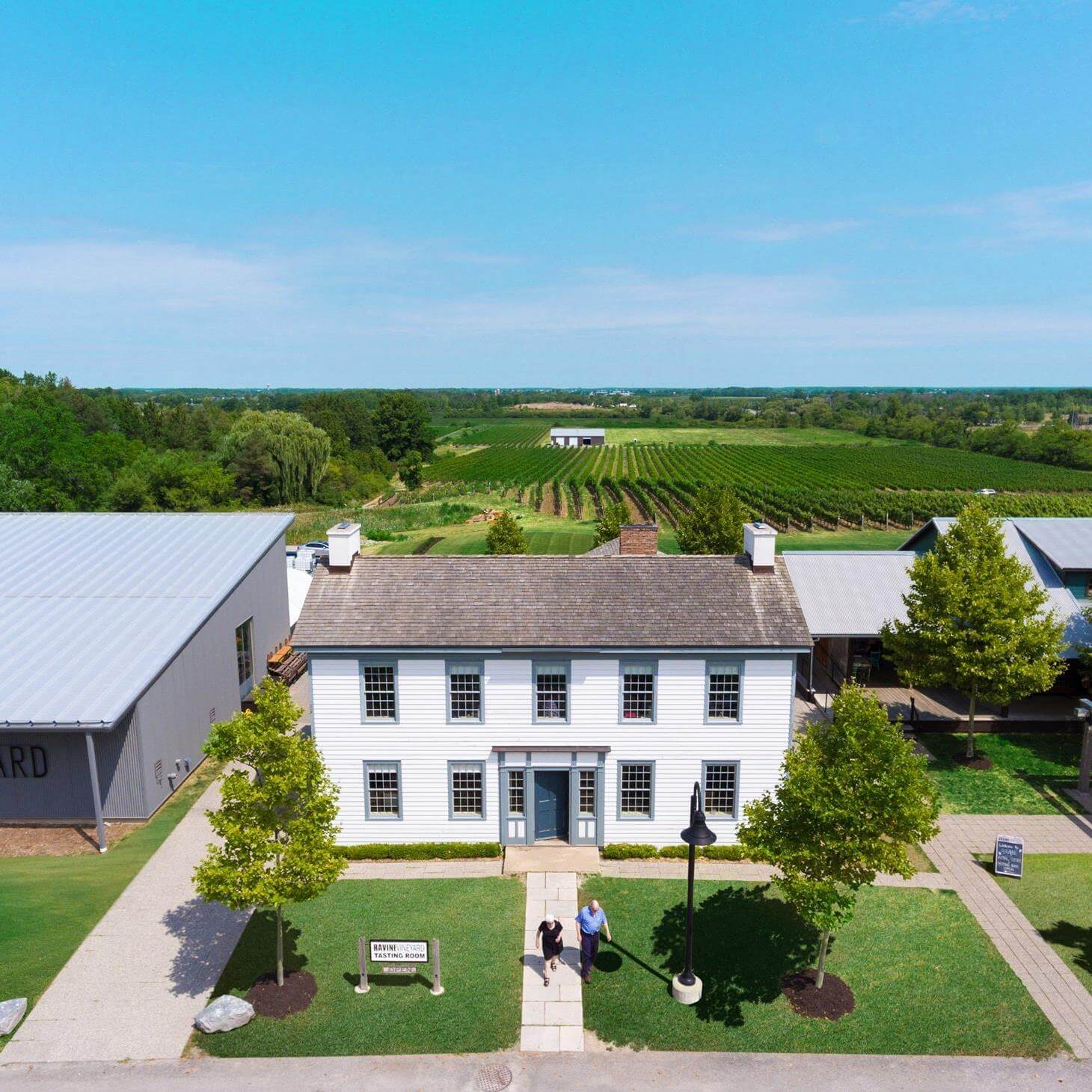 A beautiful historic building in Niagara with rolling fields of vineyards behind it