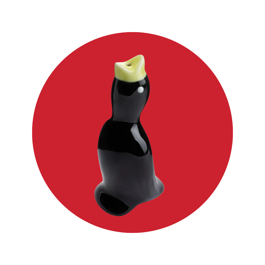 A black pie bird with a yellow beak on a red decorative circle background.