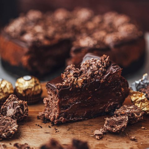 A slice of cheesecake with Ferraro Rocher chocolates around it.