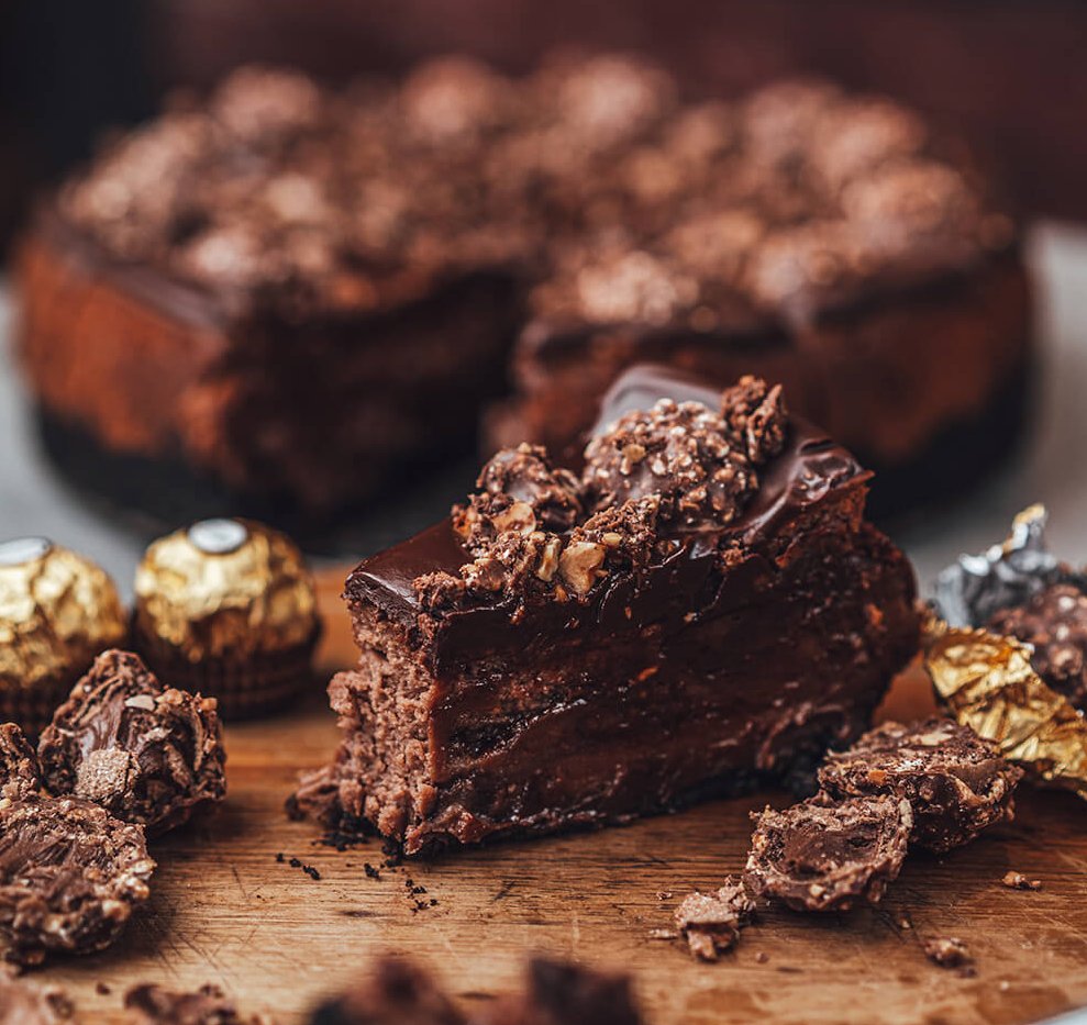 A slice of cheesecake with Ferraro Rocher chocolates around it.