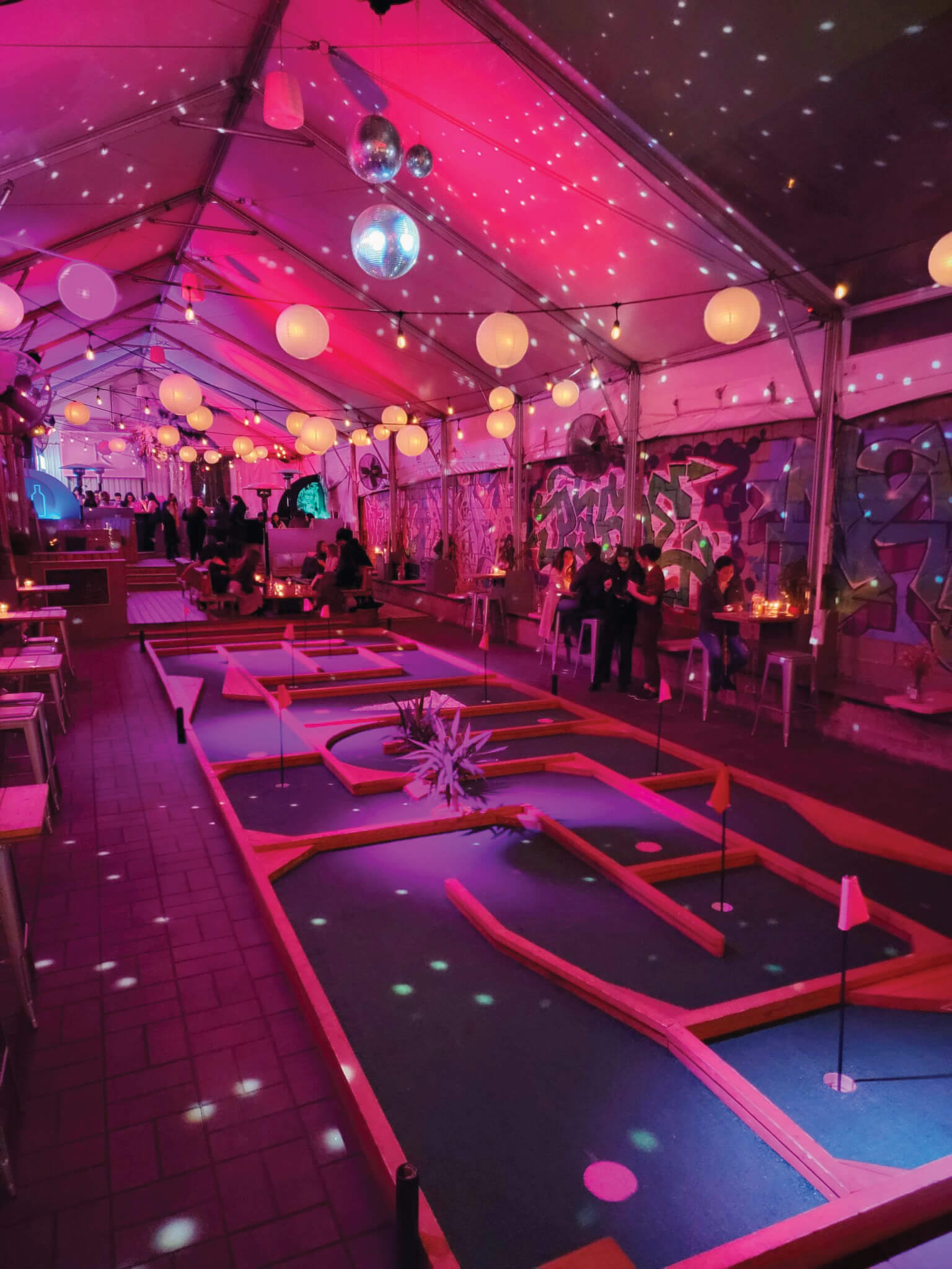 The interior of a nighttime venue with purple lighting.