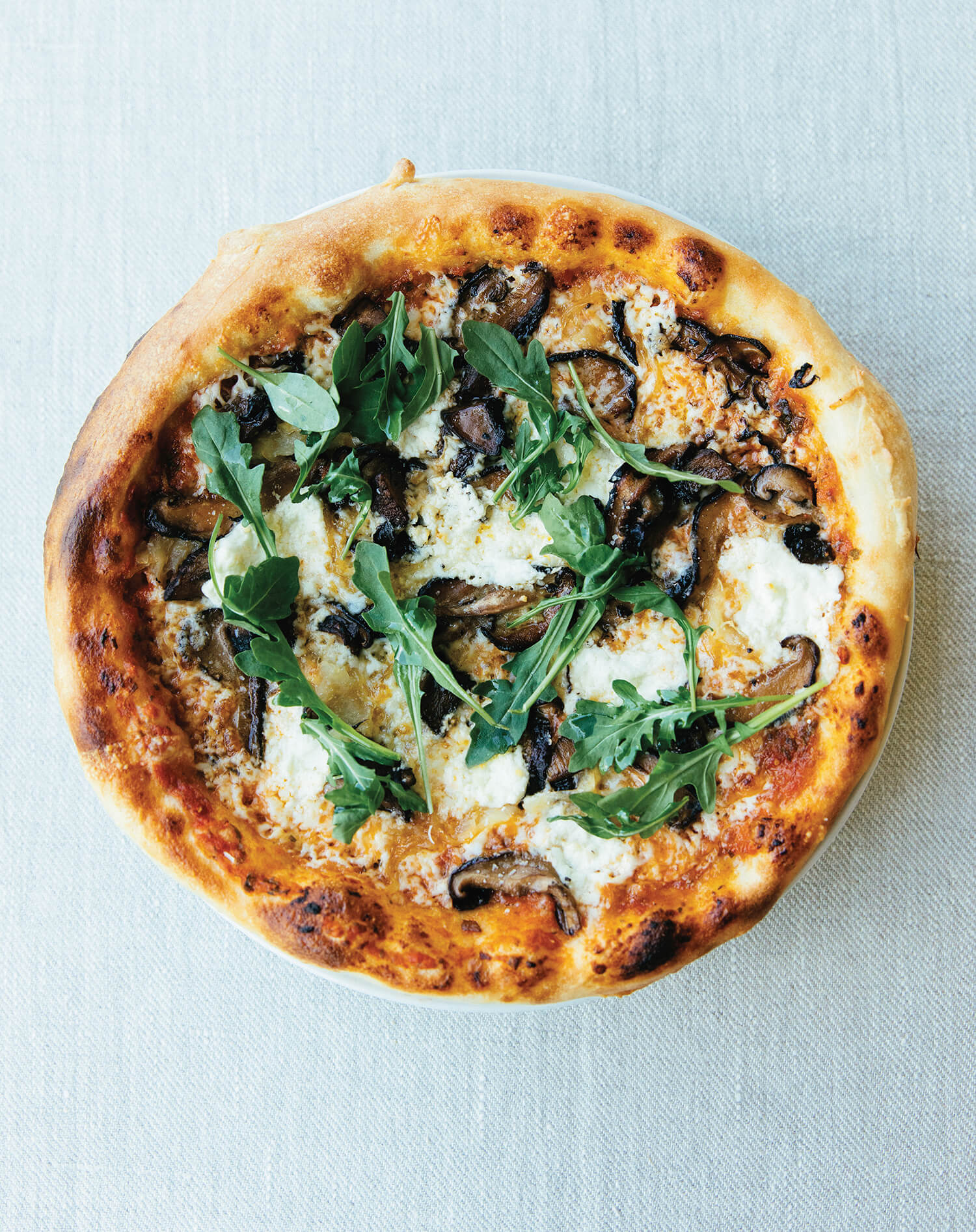 A whole pizza on a light blue background