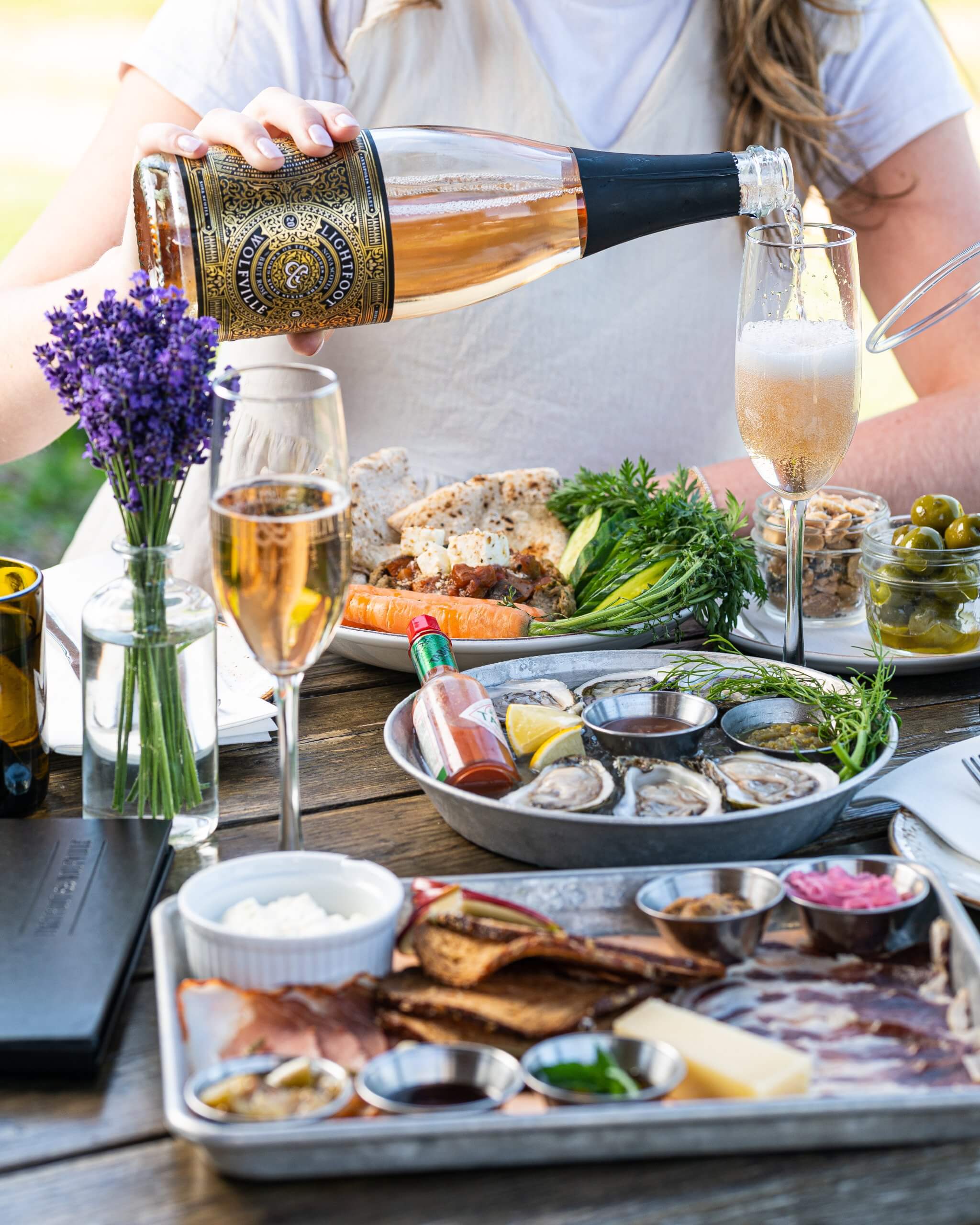 A woman pouring wine at a restaurant patio table