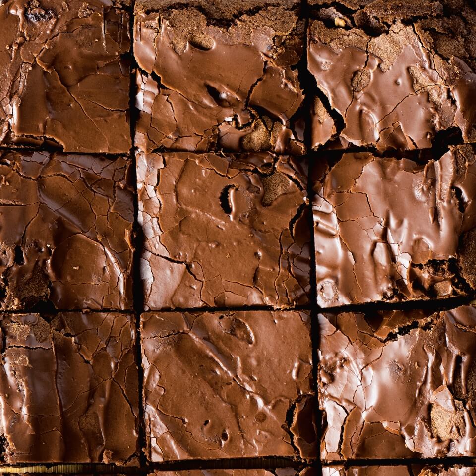 A close-up of a pan of brownies sliced into squares.