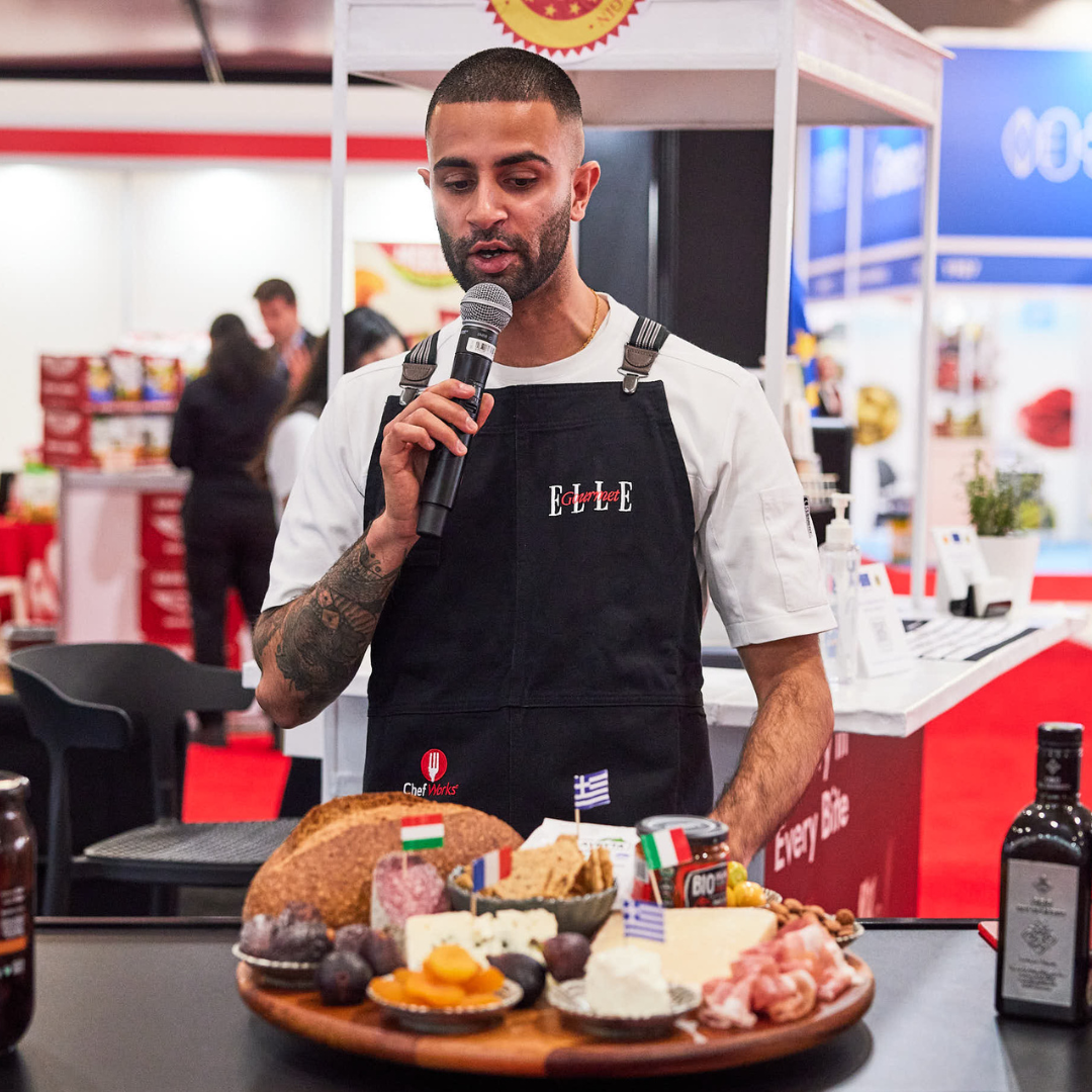 Chef Imrun Texeira speaks into a microphone at an event.
